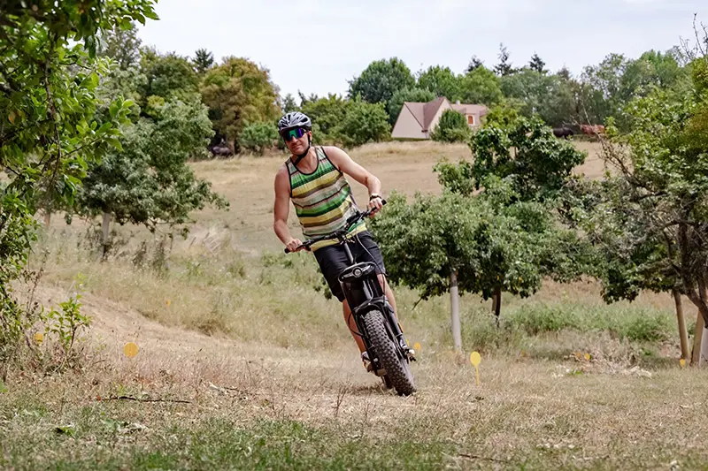 Franck Giroux de face négociant un virage sur le circuit d'initiation en trottinette électrique tout-terrain.