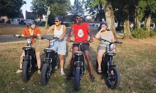 Groupe de quatre personnes alignées sur leurs trottinettes électriques tout-terrain pour une sortie d'équipe dans le Perche.
