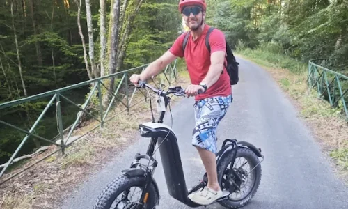 Franck Giroux sur sa trottinette électrique tout-terrain sur un pont forestier au cœur de la forêt de Bellême.